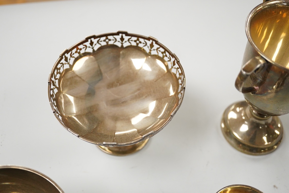 Five assorted George V silver trophy cups including two tri-handled, approx. 12.2cm and a silver bon-bon dish, with pierced border, 19.3oz.